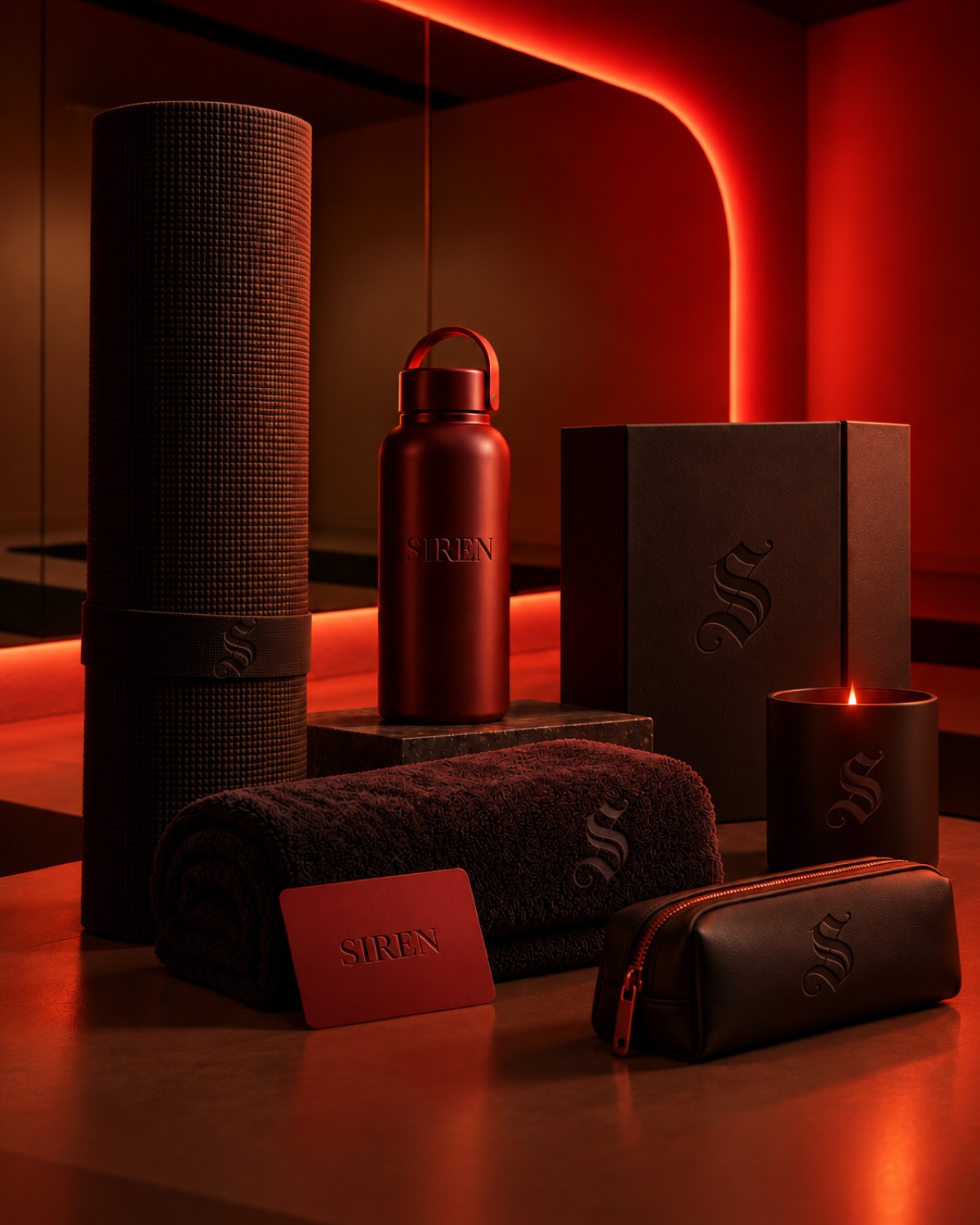 The Siren product family, mat, bottle, towel, candle and pouch, lit in red